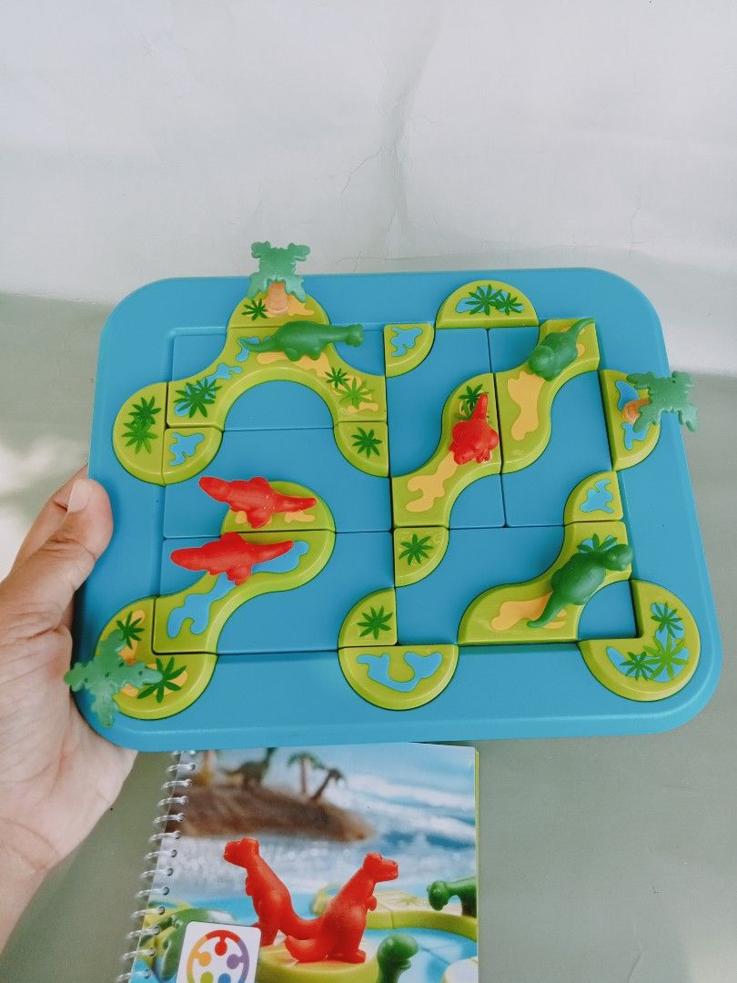 SmartGames Mystic Islands (Category: Board Games & Puzzles) located in Rosario. Submitted by elysedeclutter (Listing ID 1463379834, Image 2). Description: - Fun dinosaur-themed logic puzzle game for kids. - Helps develop problem-solving skills. - Comes with game board, dinosaur pieces, and challenge booklet. - Perfect for travel or quiet playtime..