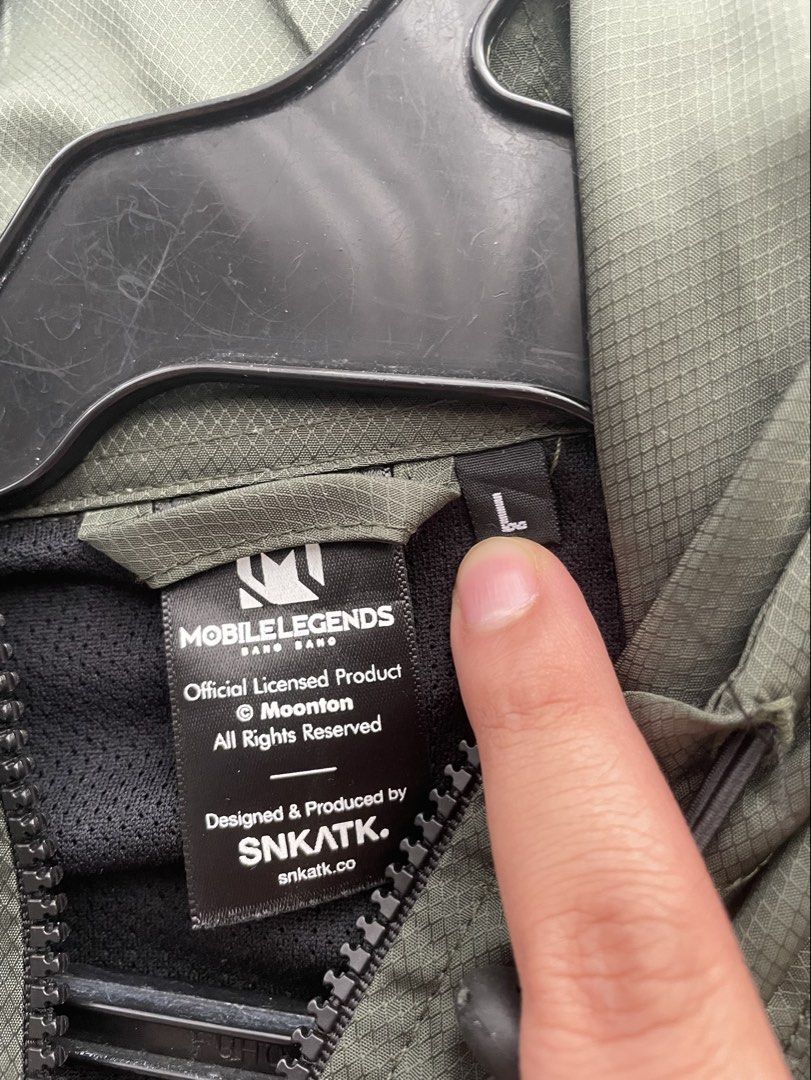 SNK ATK green wind breaker jacket (Category: Coats, Jackets and Outerwear) located in Makati City. Submitted by crisbeooo (Listing ID 1463377508, Image 3). Description: Size L SNK ATK collab with Mobile Legends Bang Bang With 4 pockets Used for a few times, no issues.