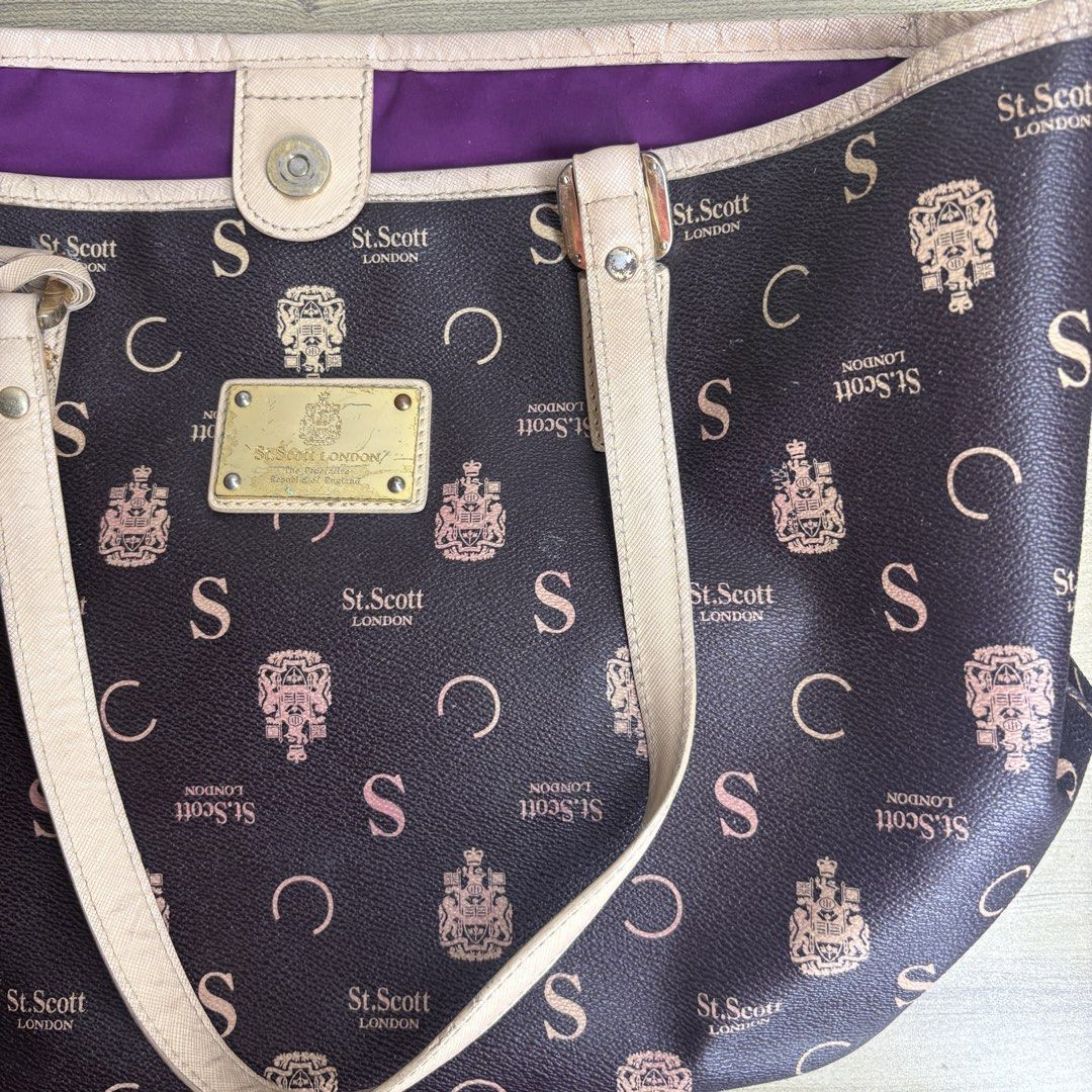 St. Scott London Monogram Tote Bag (Category: Tote Bags) located in Angeles City. Submitted by muse_archive (Listing ID 1463434482, Image 2). Description: - Authentic St. Scott London tote bag - Signature brown monogram print - Beige handles and trim - Secure magnetic snap closure - Vibrant purple interior lining - Interior zippered pocket and slip pocket - Comes with St. Scott London charm .