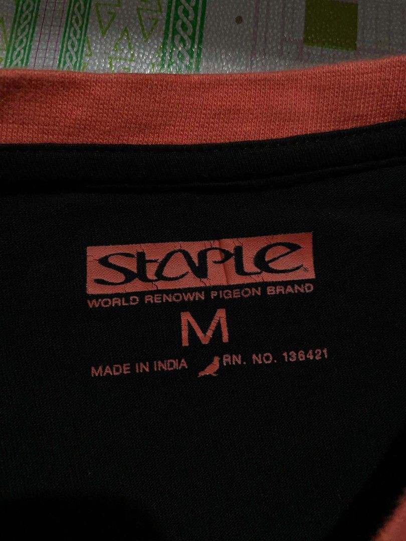 Staple "Pigeon " tee (Category: Tshirts & Polo Shirts ) located in Aroroy. Submitted by dr0p-a-dr1p (Listing ID 1463431230, Image 2). Description: - Brand: Staple - Color: Black with light blue sleeves and orange collar - Graphic: Unique abstract pigeon design in grey, black, and orange - Material: 100% Cotton - Size: Medium (M) - Style: Casual wear.