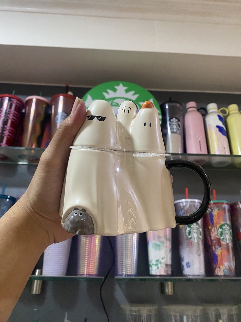 Starbucks Halloween Ghost Mug with Cat (Category: Coffee & Tea Tableware) located in Paranaque City. Submitted by jayisnottyfound (Listing ID 1463410050, Image 1). Description: - Adorable Starbucks mug perfect for Halloween! - Features a fun design of ghosts with various expressions. - Includes a cute cat peeking out from the design. - Comes with a sleek black handle. - Ideal for enjoying your favorite spooky season beverages. - A must-have for H