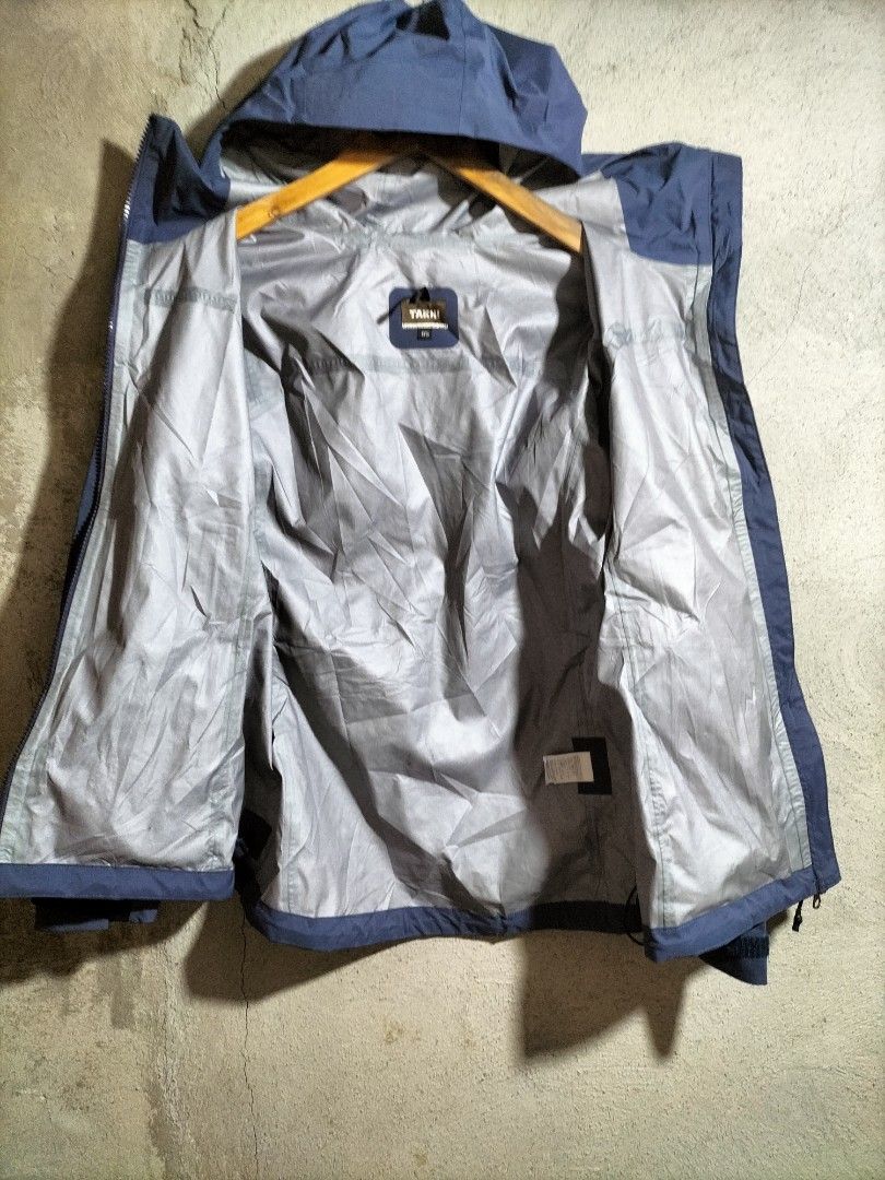 TAKHI Blue Hooded Waterproof Jacket (Category: Coats, Jackets and Outerwear) located in Valencia. Submitted by cabisaythriftshop (Listing ID 1463416782, Image 3). Description: - TAKHI blue hooded jacket - Size 85 - Waterproof/windbreaker style - Zippered pockets (front and sides) - Grey inner lining - Ideal for outdoor activities and everyday wear.