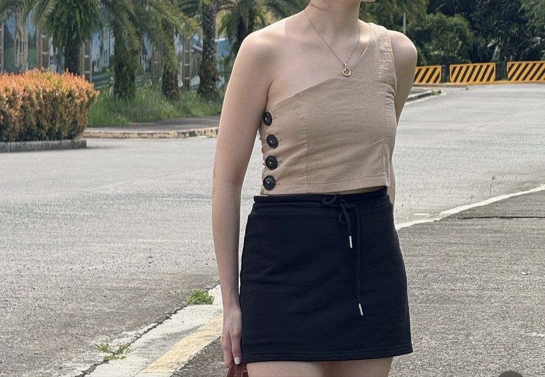 Tan One Shoulder Crop Top with Button Detail (Category: Sleeveless) located in Bacolod City. Submitted by bacolodprelovedstuffs (Listing ID 1463375003, Image 2). Description: - Tan one-shoulder crop top - Features three dark buttons on the side - Versatile: pairs well with skirts or high-waisted pants - Comfortable and stylish for casual outings or nights out - please see more photos for WW.