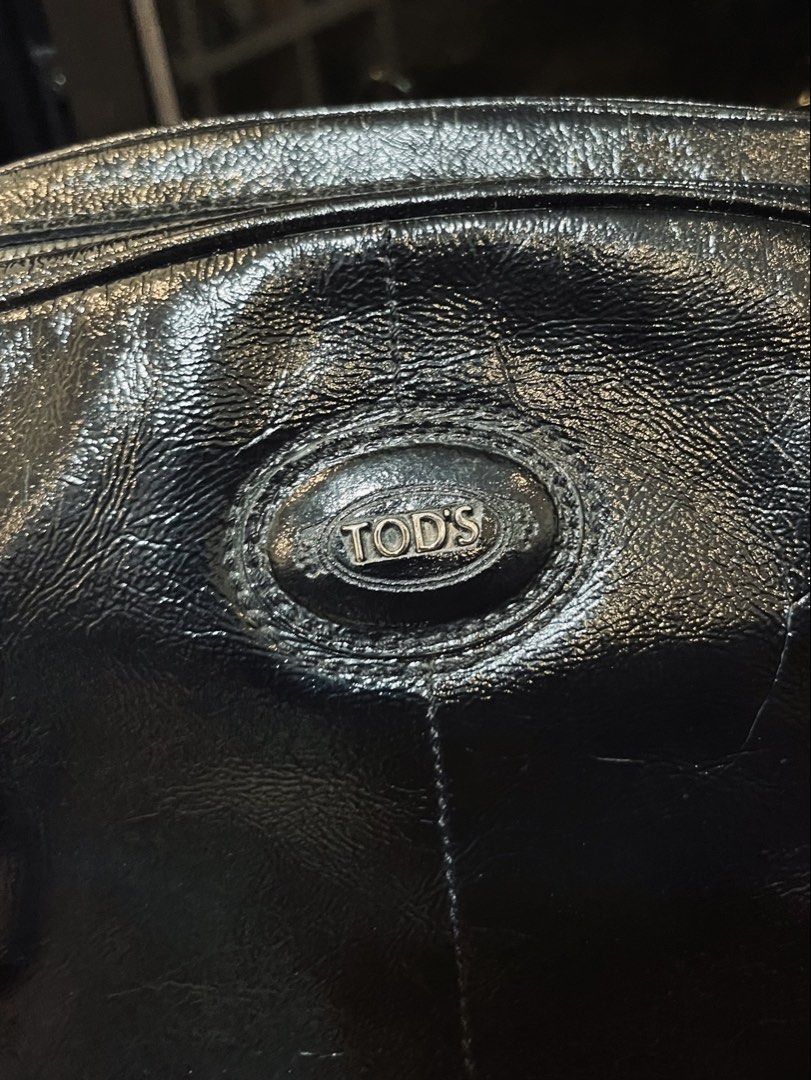 TOD'S Black Patent Leather Hobo Bag (Category: Luxury Bags & Wallets) located in Bacolod City. Submitted by vintage_vogue6100 (Listing ID 1463385916, Image 2). Description: - Authentic TOD'S hobo bag - Black patent leather - Silver hardware and buckle details - Zipper top closure - Classic, versatile design for everyday wear.