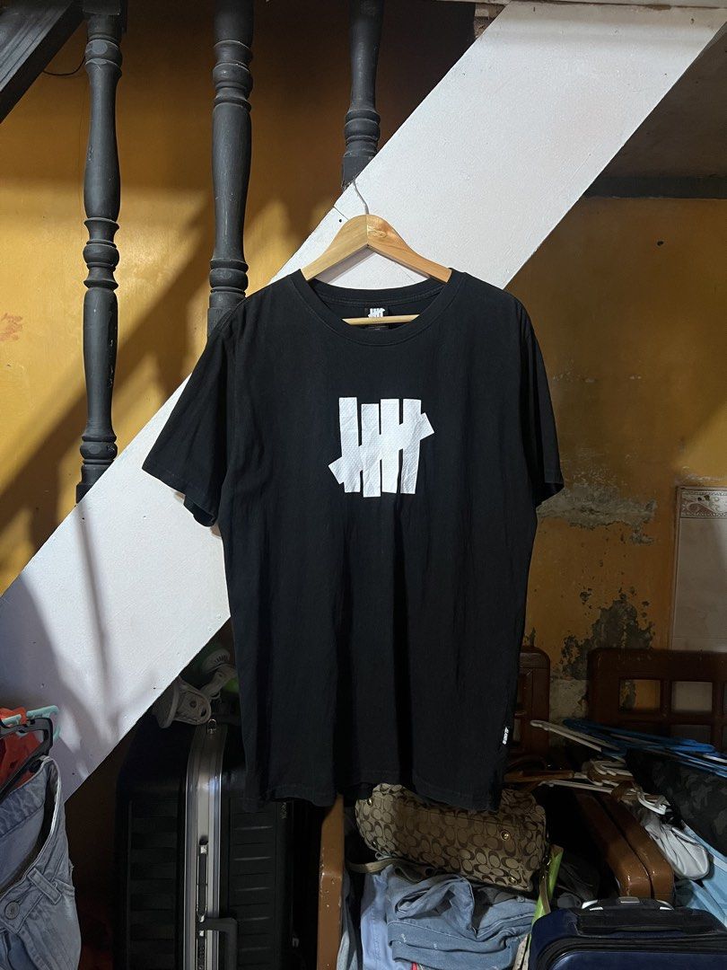 Undefeated Black Cotton T-Shirt Large (Category: Tshirts & Polo Shirts ) located in Butuan. Submitted by nikthrift. (Listing ID 1463334337, Image 1). Description: - Brand: Undefeated - Color: Black - Material: 100% Cotton - Features: Undefeated logo on tag, woven tag on side seam - Style: Comfortable, casual, everyday wear -with tiny pinhole sa back.