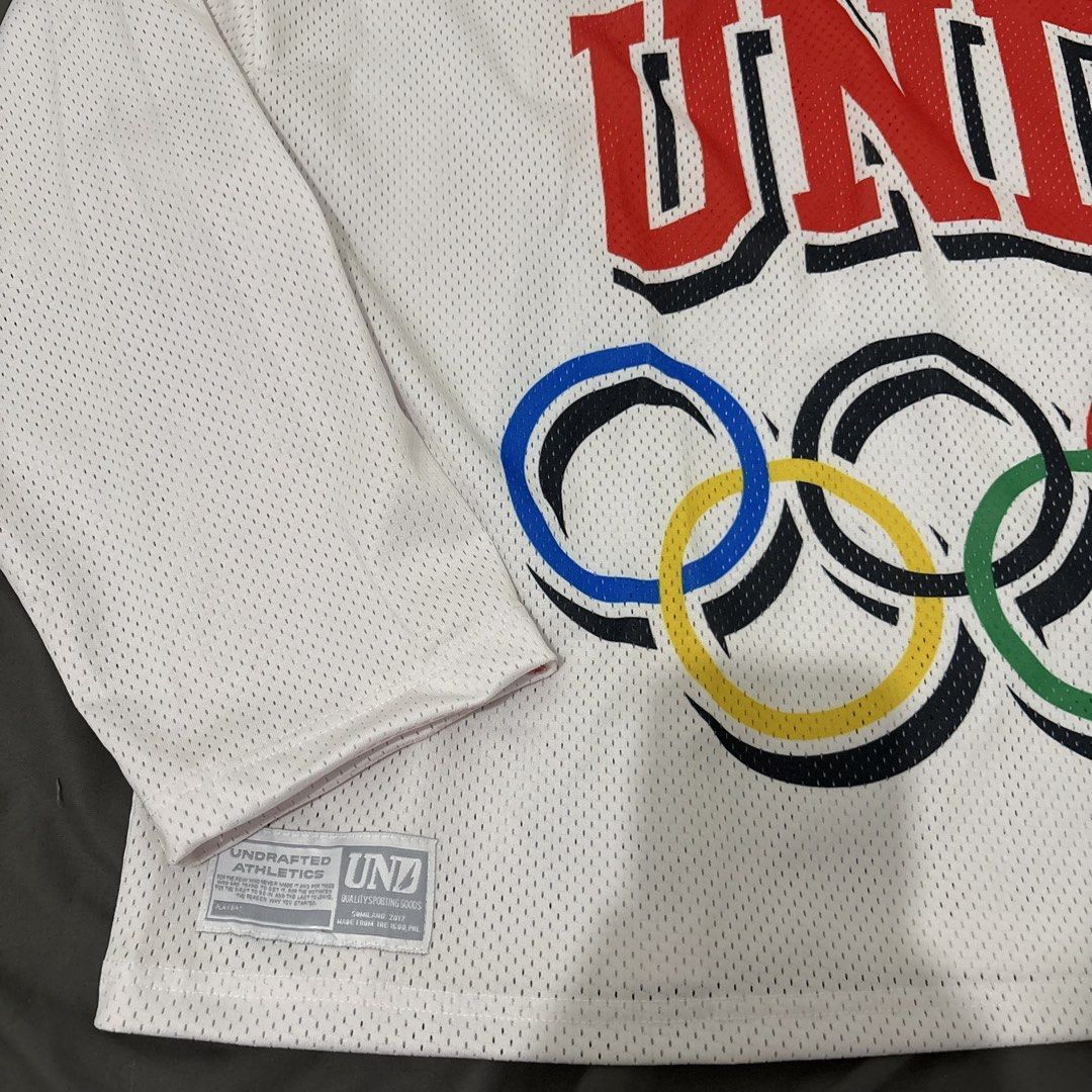 Undrafted jersey longsleeves (Category: Activewear) located in Makati City. Submitted by sseurekiii (Listing ID 1463397019, Image 3). Description: - Brand: UNDFTD - Item: Long Sleeve Jersey - Color: White - Material: Mesh - Size: XL - Features: UND logo and Olympic rings graphic - Never been used .