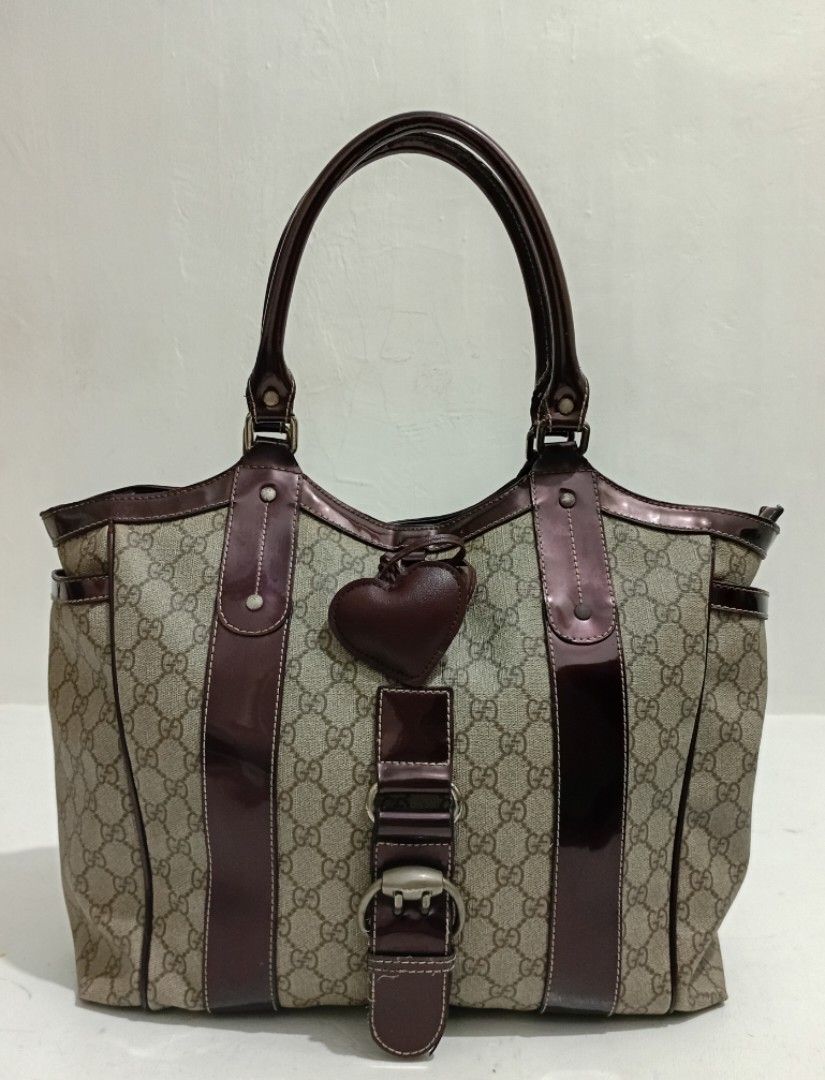 Vintage Gucci Monogram Large Structured Punch Tote Bag (Category: Luxury Bags & Wallets) located in Navotas City. Submitted by ms.soulana (Listing ID 1463326718, Image 2). Description: PreOwned Lightly Used WellUsed Authentic Rarefinds Vintage Iconic Gucci GG monogram canvas & Patent leather trim Structured Punch tote bag -Large beige. ,burgundy - Adorable heart charm detail - Glossy dark red trim - Spacious interior for essentials - Sturdy and c