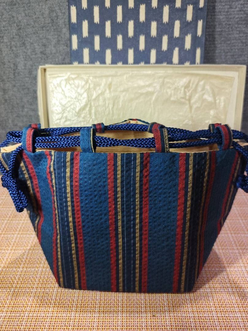 Vintage Japanese Striped Pouch with Box (Category: Purses & Pouches) located in San Leonardo. Submitted by burgossanleonardo.12345 (Listing ID 1463455976, Image 1). Description: - Authentic Japanese pouch - Features traditional blue, red, and gold stripes - Comes with original decorative box - Includes braided blue cords - Ideal for storing small items or as a decorative piece.