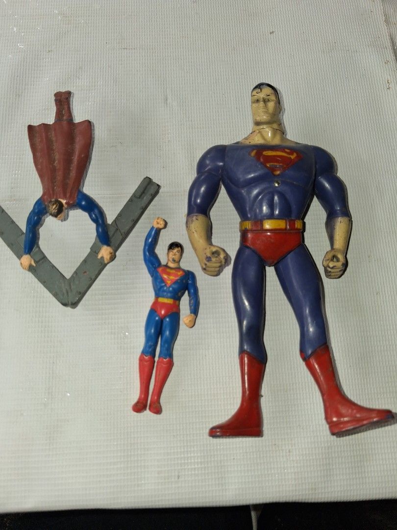 Vintage Superman Action Figures Lot (Category: Figurines & Statues) located in Manila. Submitted by marcas022798212 (Listing ID 1463348798, Image 1). Description: - Lot of 3 Superman action figures - Includes 1 large figure and 2 smaller figures - One smaller figure features a cape and is attached to a grey stand - Please note: Some paint wear is present on the figures - Ideal for any Superman fan or collector.