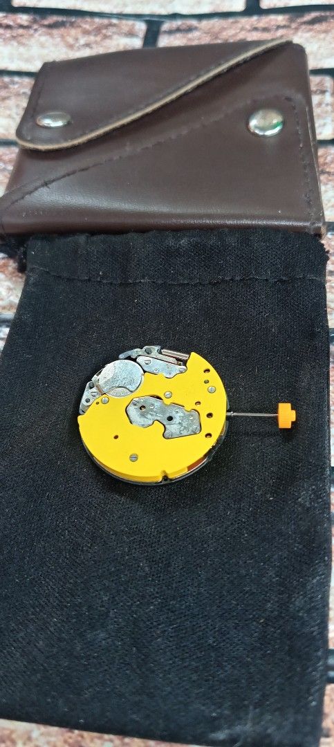 Watch Movement with Leather Pouch (Category: Women's Watches) located in San Pedro. Submitted by precisiontracer (Listing ID 1463417414, Image 1). Description: - Watch movement suitable for repair or replacement - Features a yellow and grey finish - Comes with a black protective pouch - Includes a brown leather case with two snap buttons - Ideal for watch enthusiasts and repairers.