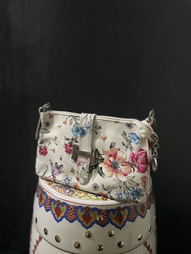 White Floral Shoulder Bag with Silver Buckle (Category: Shoulder Bags) located in Caloocan City. Submitted by zealgem_d3432f (Listing ID 1463529556, Image 1). Description: - Cute white shoulder bag - Vibrant floral print - Silver buckle closure on front flap - Small size, ideal for essentials - Adjustable strap - Small charm attached to zipper - Perfect for casual day outs Please feel free to message me if there are any inquiries or requests for 