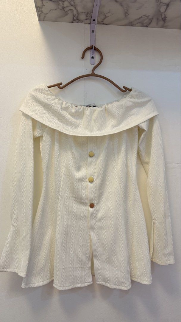 White Off-Shoulder Textured Top with Buttons (Category: Blouses) located in Angeles City. Submitted by hooni_park (Listing ID 1463481180, Image 1). Description: - White off-shoulder top - Textured fabric with vertical stripe pattern - Three buttons down the front - Long sleeves with flared cuffs - Perfect for dressing up or down - Easy to style for any outfit.
