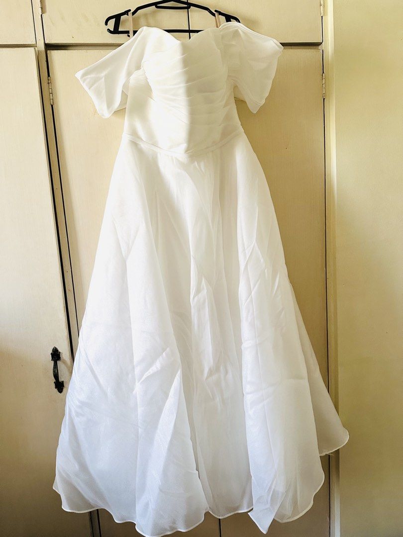White Off-Shoulder Wedding Dress with Veil (Category: Evening dresses & gowns) located in Dasmarinas. Submitted by chocnutpie (Listing ID 1463555642, Image 3). Description: - With asymmetric off-shoulder sleeves for style - Lace-up back for a custom, adjustable fit - Perfect for civil wedding / reception dress - Free size (freely adjustable from chest to waist with corset at the back) - Ankle-length for 5’3” height - With included ribbon accessor
