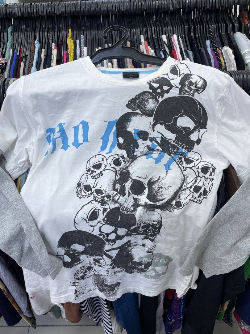 White Skull Graphic T-Shirt (Category: Tshirts & Polo Shirts ) located in Lucena. Submitted by riyizthriftz (Listing ID 1463496796, Image 2). Description: - White t-shirt with a large graphic print of skulls and blue text - Features long sleeves underneath for a layered look - Brand: Next - Perfect for a casual, edgy style - Please check photos for detailed condition - Y2k - Goth - Vintage .