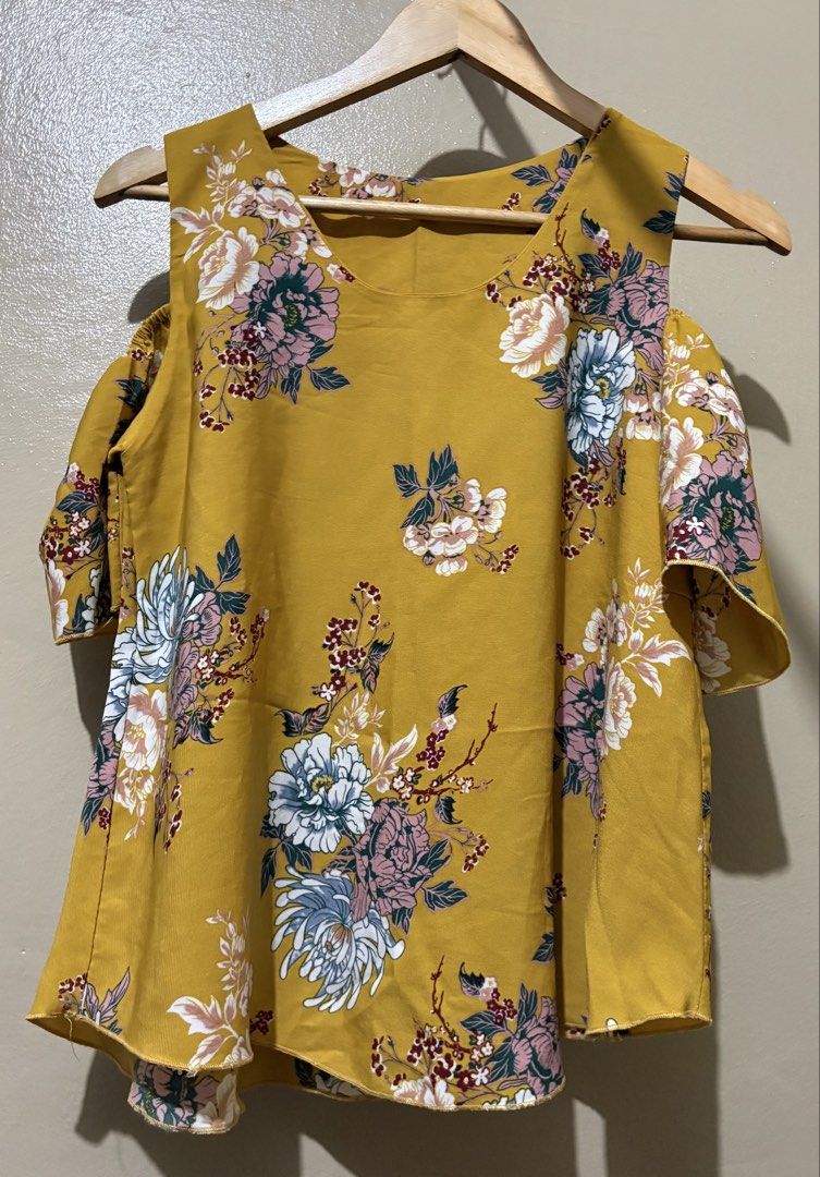 Yellow Floral Cold Shoulder Top (Category: Blouses) located in Manila. Submitted by stella_mari27 (Listing ID 1463445475, Image 1). Description: - Vibrant yellow top with a lively floral print. - Features stylish cold shoulder cut-outs. - Short sleeves for comfort. - Flattering slightly flared hemline. - Versatile for casual days or brunch dates. - Easily pairs with jeans or skirts..