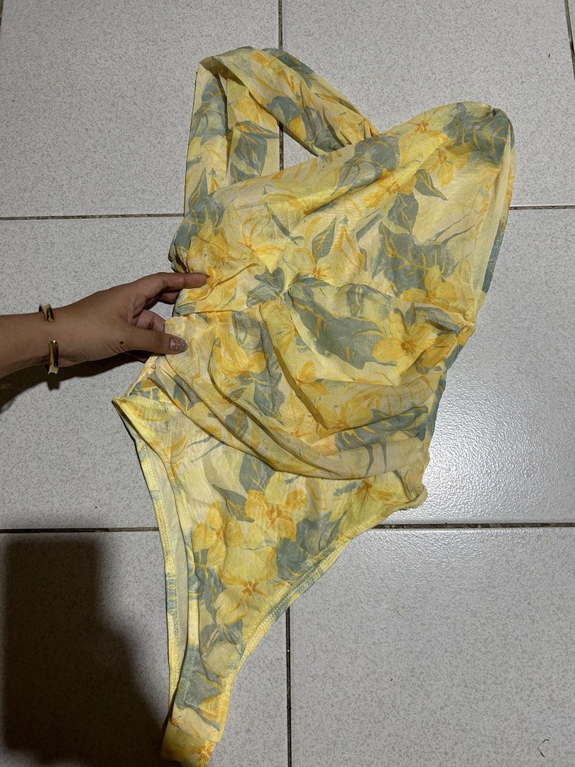 Yellow Floral One Shoulder Ruched Bodysuit (Category: Others Tops) located in Cavite. Submitted by handpickedbyisha (Listing ID 1463519575, Image 2). Description: - Adorable yellow one-shoulder bodysuit - Features a charming floral print - Stylish ruching details on the side - Made from lightweight and flowy fabric - Versatile: perfect for beach days or nights out - Easily pairs with shorts or skirts.