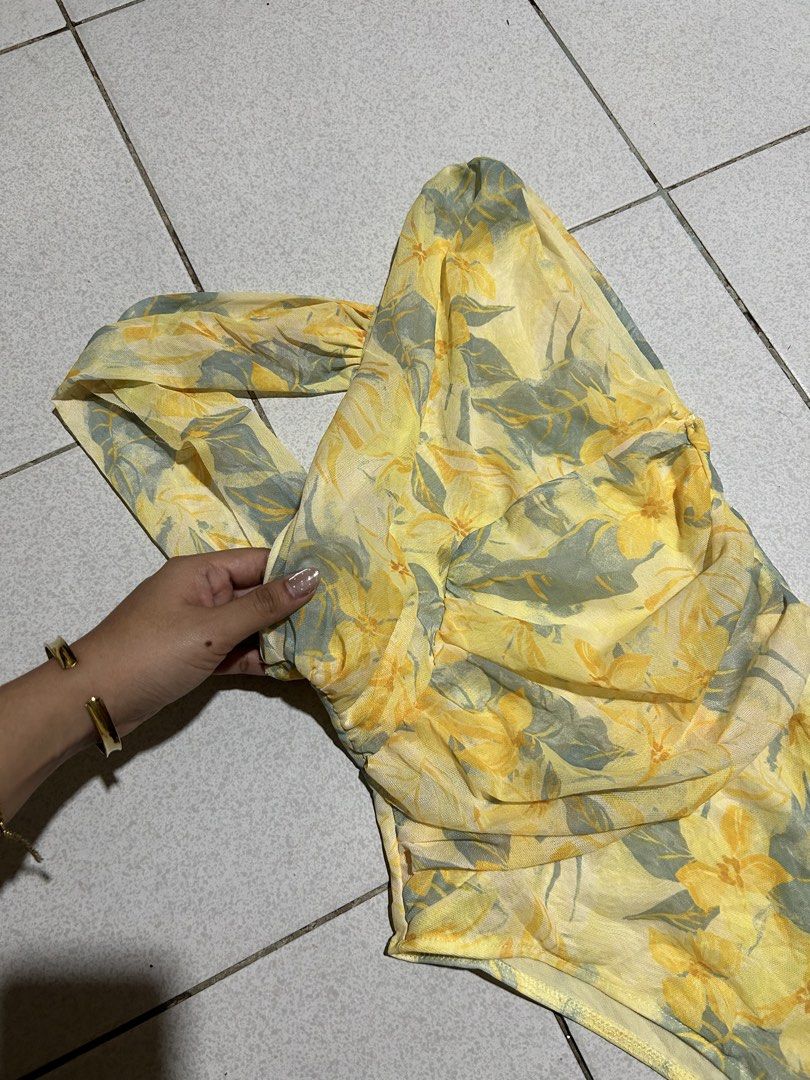 Yellow Floral One Shoulder Ruched Bodysuit (Category: Others Tops) located in Cavite. Submitted by handpickedbyisha (Listing ID 1463519575, Image 3). Description: - Adorable yellow one-shoulder bodysuit - Features a charming floral print - Stylish ruching details on the side - Made from lightweight and flowy fabric - Versatile: perfect for beach days or nights out - Easily pairs with shorts or skirts.