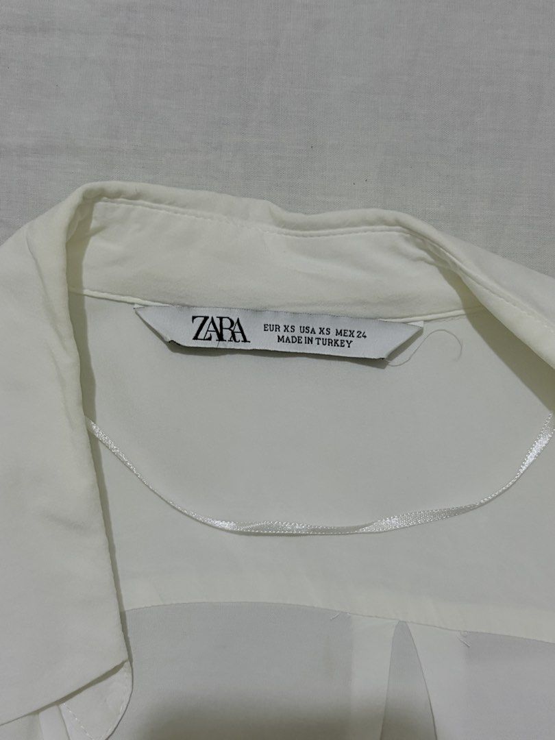 ZARA White Long Sleeve Button Up Shirt (Category: Longsleeves) located in General Mariano Alvarez. Submitted by b3yaaa (Listing ID 1463454082, Image 2). Description: - Classic white button-up shirt from ZARA - Long sleeves with button cuffs - Two chest pockets with button closures - Simple and versatile design - Perfect for layering or wearing solo - Large fit, fits XS-M.