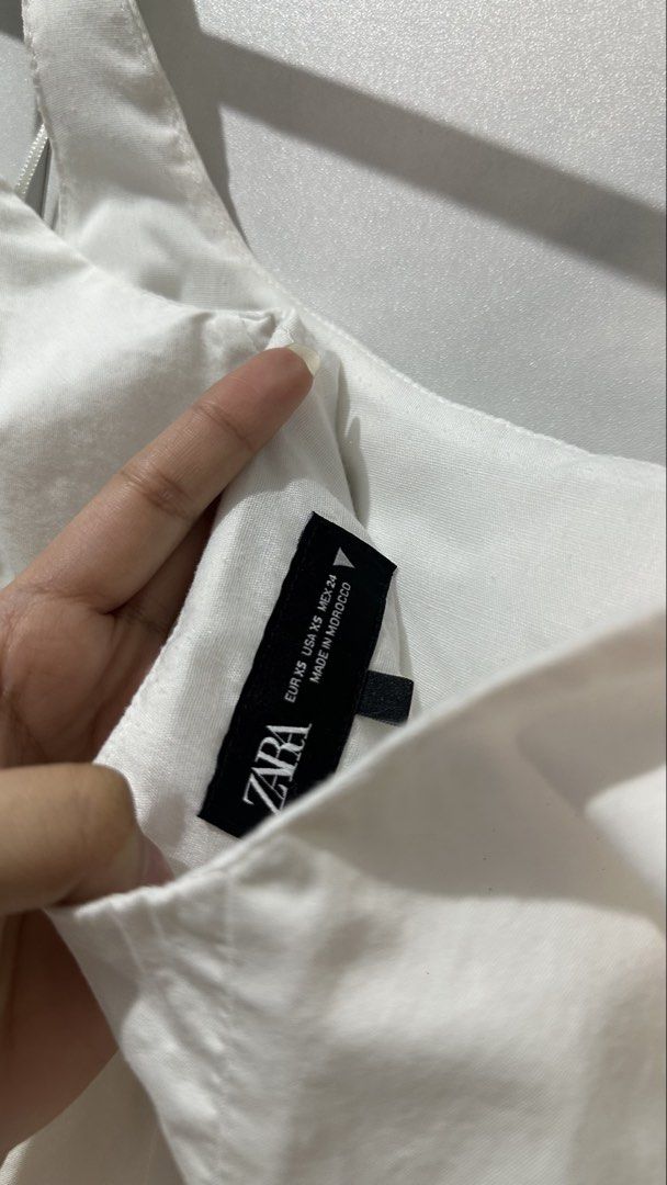 Zara White Ruffle Mini Dress (Category: Dresses) located in Manila. Submitted by nellafelix1720 (Listing ID 1463473551, Image 3). Description: - Cute white mini dress from Zara - Features a square neckline - Ruffled hem detail - Strappy design - Ideal for casual outings or beach days - Versatile styling with sandals or sneakers.