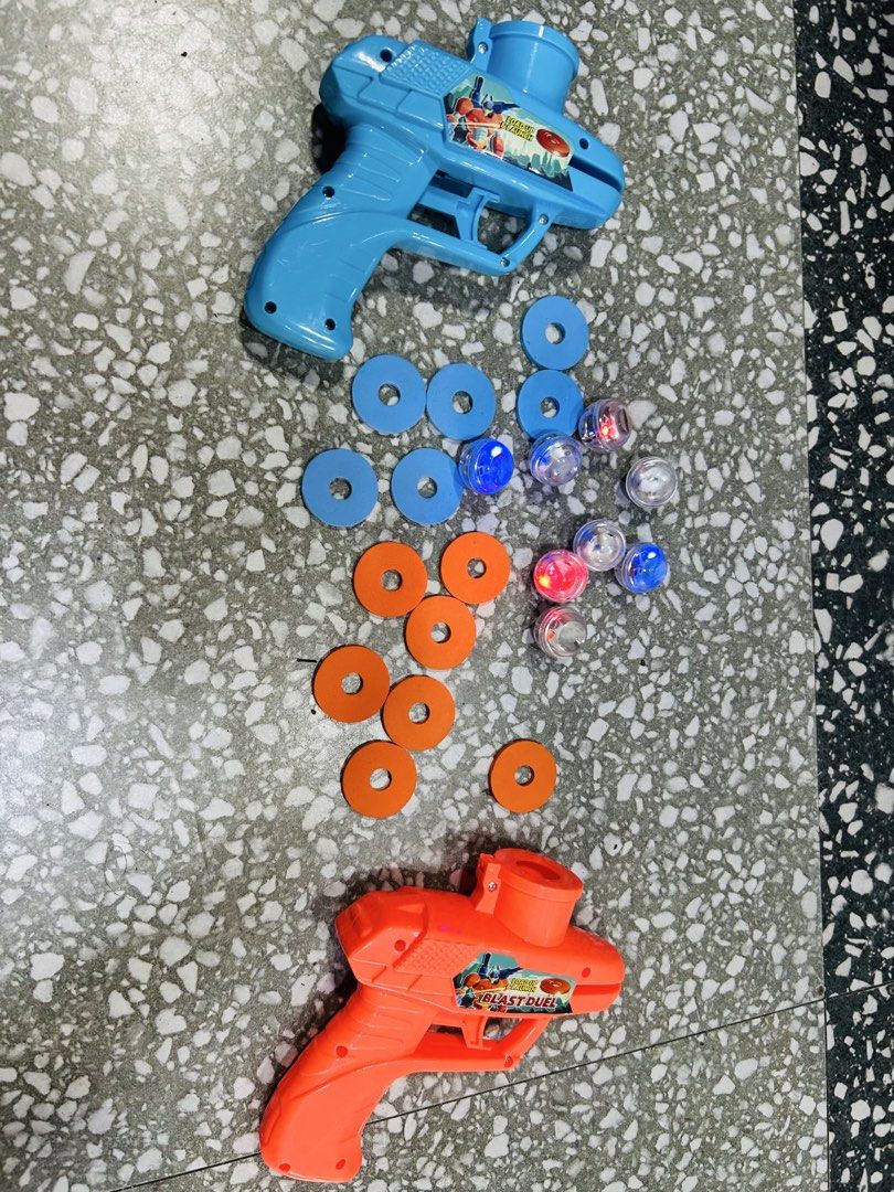 2x Light-Up Toy Guns with Discs and Balls (Category: Action & Battle Toys) located in Manila. Submitted by starbalesukandjapansurplus (Listing ID 1463586494, Image 1). Description: - Set includes 2 toy guns (1 blue, 1 orange) - Comes with multiple blue and orange discs - Includes several small, clear balls that light up in red and blue - Perfect for kids' playtime - Suitable for both indoor and outdoor fun.