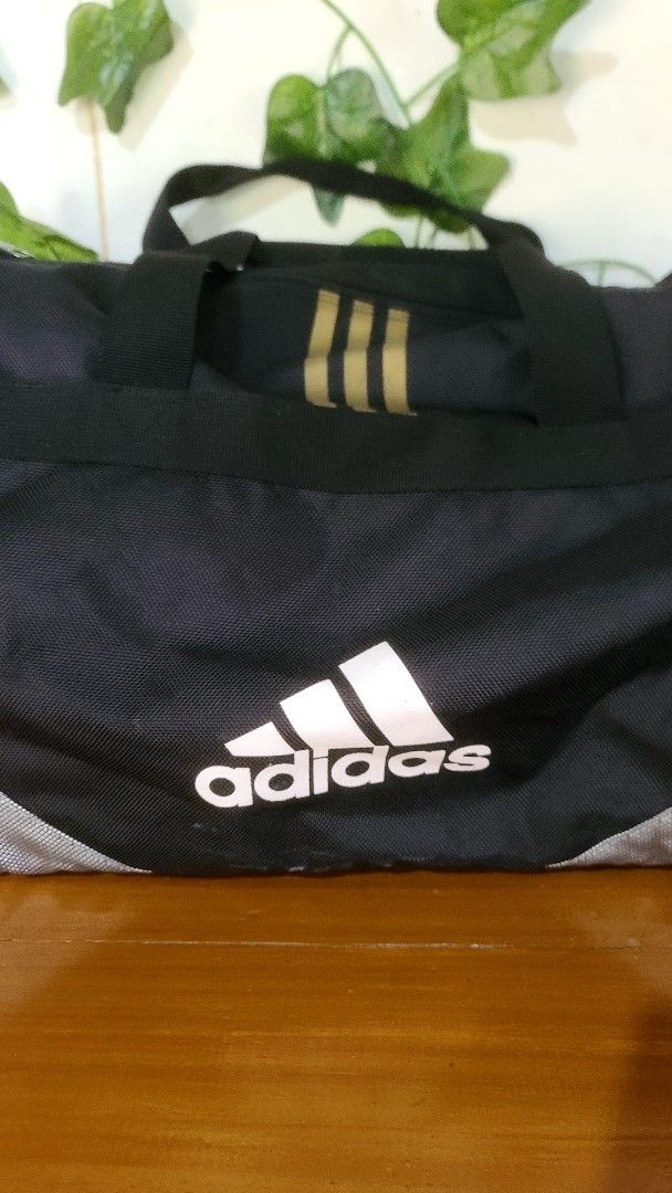 Adidas Duffel Bag Black Gold (Category: Sling Bags) located in Baguio. Submitted by phoeberose33384 (Listing ID 1463739192, Image 2). Description: - Black Adidas duffel bag - Gold accents - Main compartment and side pockets - Zippers in good working condition - Sturdy handles - Ideal for gym or travel - Approximately 21 inches long.