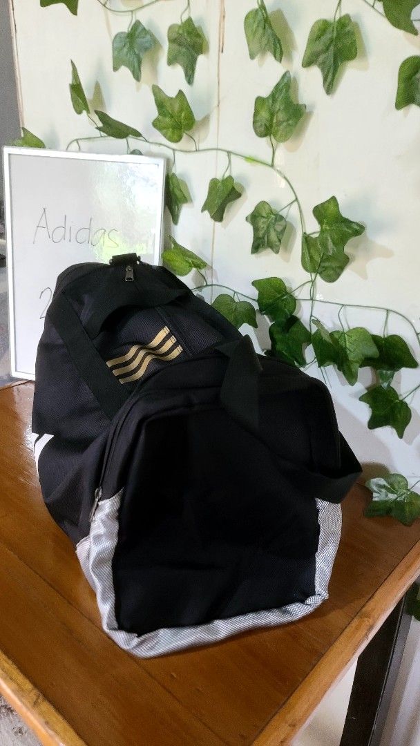 Adidas Duffel Bag Black Gold (Category: Sling Bags) located in Baguio. Submitted by phoeberose33384 (Listing ID 1463739192, Image 3). Description: - Black Adidas duffel bag - Gold accents - Main compartment and side pockets - Zippers in good working condition - Sturdy handles - Ideal for gym or travel - Approximately 21 inches long.