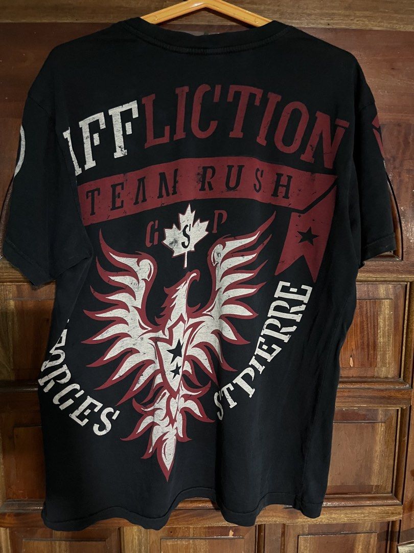 Affliction Georges St-Pierre "Rush" T-Shirt (Category: Tshirts & Polo Shirts ) located in Cebu City. Submitted by rockall24455 (Listing ID 1463741664, Image 2). Description: - Black Affliction T-Shirt - Georges St-Pierre "Rush" graphic on front and back - Size: Large 21.5x28 dimes - Material: 100% Cotton - Made in USA - Care Instructions: Machine wash cold, do not bleach, tumble dry low, do not iron - Ideal for MMA and UFC enthusiasts.
