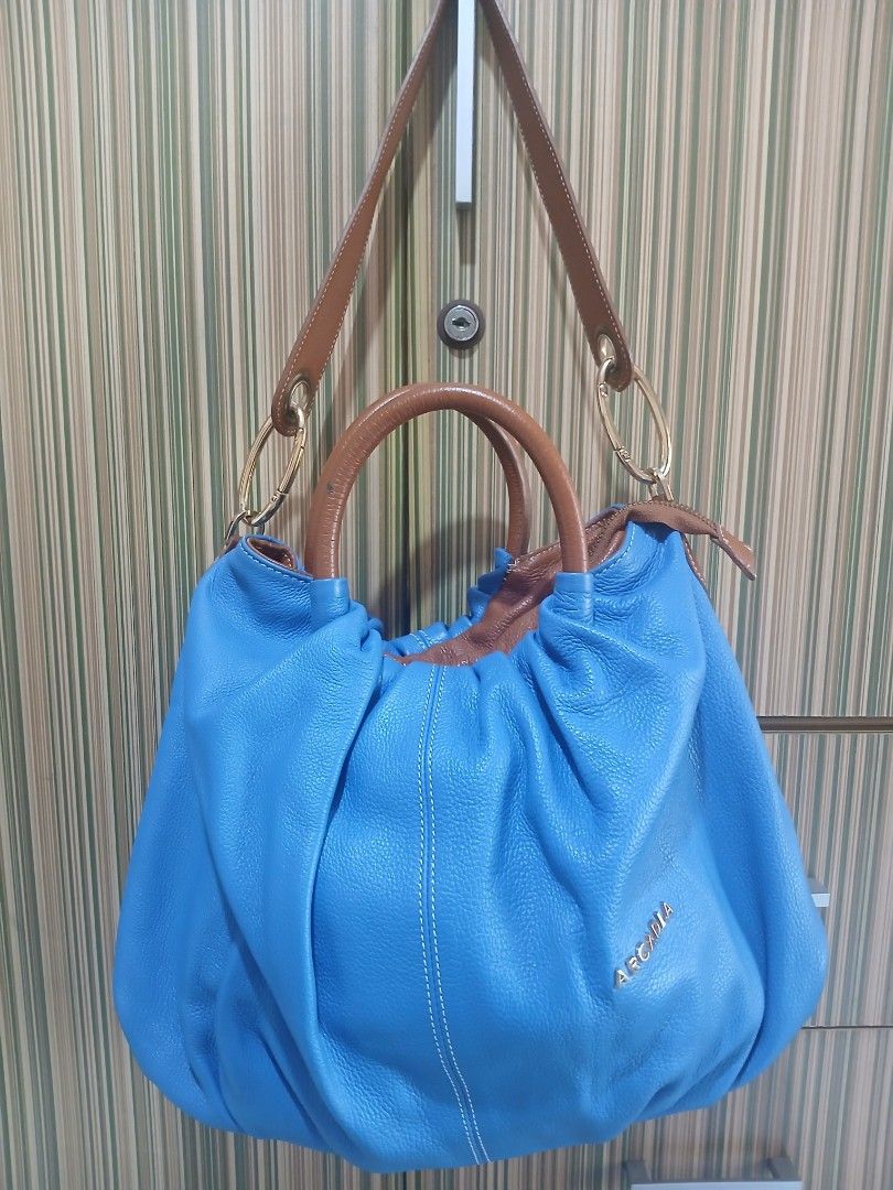 Arcadia Blue Leather Hobo Bag (Category: Shoulder Bags) located in Taguig. Submitted by demsclosetph (Listing ID 1463617202, Image 1). Description: - Blue leather hobo bag by Arcadia - Tan leather handles and strap - Gold hardware details - Interior zip pocket and slip pocket - Made in Italy - Spacious and stylish - Perfect for everyday use.
