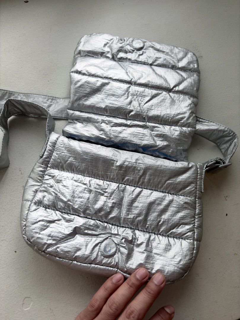 Authentic Beyond The Vines Metallic Poofy Bag (Category: Cross-body Bags) located in Mandaluyong City. Submitted by wear_your_style (Listing ID 1463720160, Image 2). Description: Store bought for ₱4,800 i think. This is a limited edition bag (Holiday). It’s metallic silver but it’s not the cheap metallic finish. Parang matte finish ganun and it doesn’t chip off. Nylon base material. Adjustable strap pero at max nasa bewang ko lang yung bag (im 5’