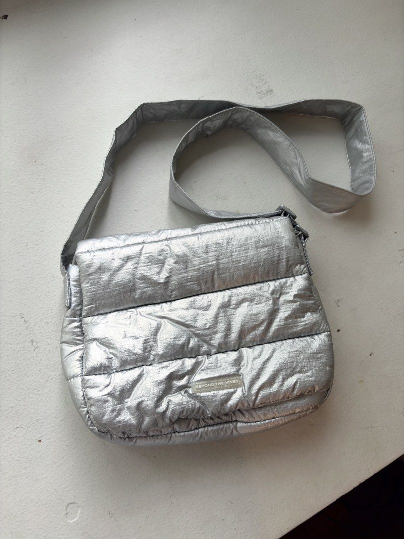 Authentic Beyond The Vines Metallic Poofy Bag (Category: Cross-body Bags) located in Mandaluyong City. Submitted by wear_your_style (Listing ID 1463720160, Image 1). Description: Store bought for ₱4,800 i think. This is a limited edition bag (Holiday). It’s metallic silver but it’s not the cheap metallic finish. Parang matte finish ganun and it doesn’t chip off. Nylon base material. Adjustable strap pero at max nasa bewang ko lang yung bag (im 5’