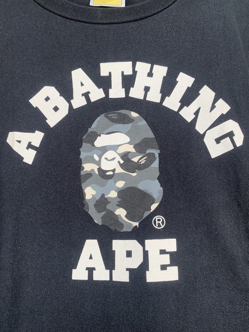 Bape college tee GITD (Category: Tshirts & Polo Shirts ) located in Aloran. Submitted by chester78864 (Listing ID 1463658078, Image 2). Description: - Classic black A Bathing Ape (BAPE) t-shirt - Features iconic camo ape head graphic on the front - BAPE logo arched above, 'APE' below the graphic - Small ape head tag detail on sleeve and hem - Made from 100% comfortable cotton - Ideal for any streetwear enthusiast.