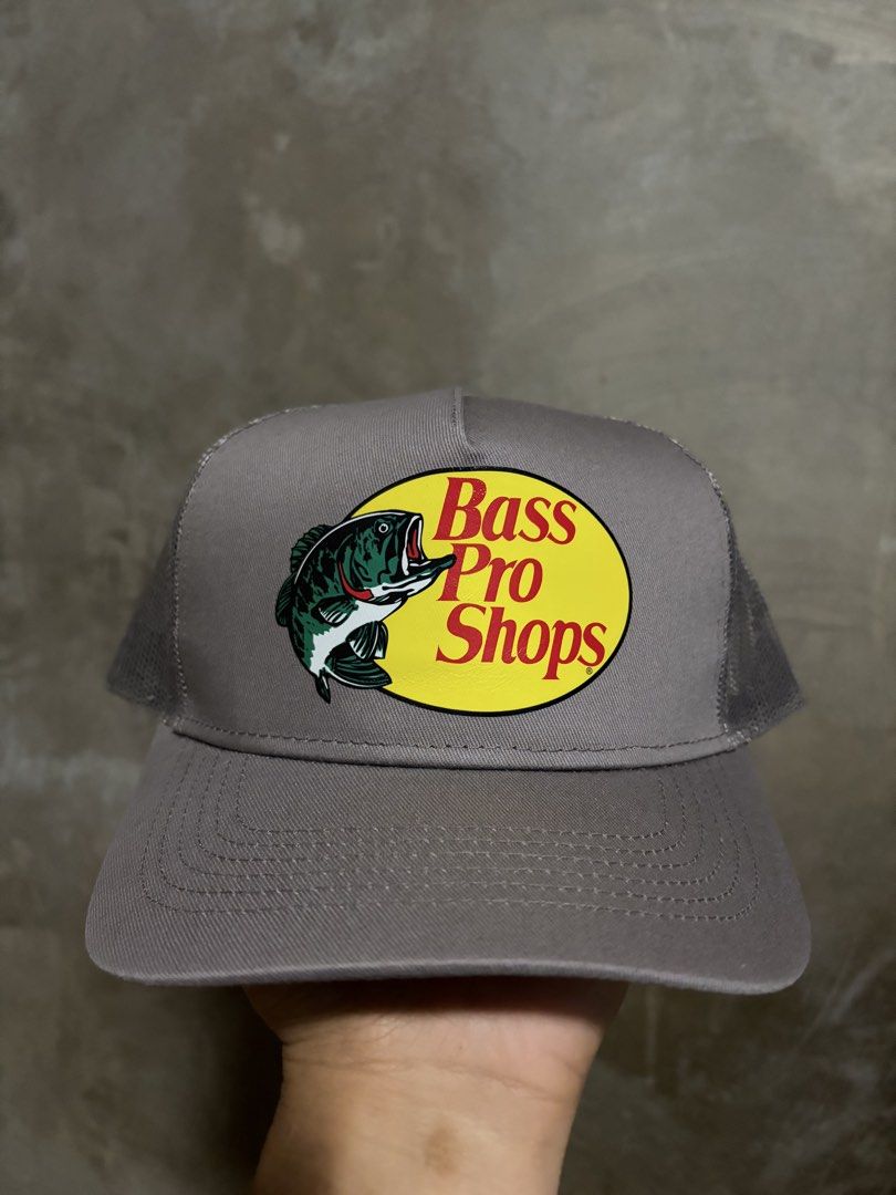 Bass Pro Shops Mesh Trucker Cap Grey OSFM (Category: Caps & Hats) located in Guihulngan. Submitted by fbthriftgoodsniace (Listing ID 1463613672, Image 1). Description: - Grey Bass Pro Shops trucker cap - Features iconic Bass Pro Shops logo with fish graphic - Breathable mesh back - Adjustable snapback closure for a custom fit - One Size Fits Most (OSFM) - Ideal for fishing adventures or everyday casual style.