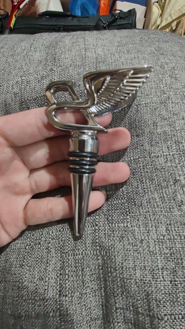chrome plated Bentley Winged B Bottle Stopper (Category: Vintage Collectibles) located in Baguio. Submitted by maryhazel.22 (Listing ID 1463668582, Image 2). Description: - Authentic Bentley Winged B logo bottle stopper - Sleek, shiny chrome finish - Comes with a soft black velvet pouch -no box - Ideal for Bentley enthusiasts and as a unique gift - Keeps wine fresh with a touch of luxury.