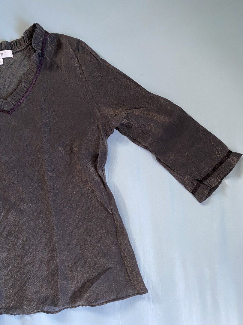 Bess Metallic Grey Ruffled V-Neck Top (Category: Sleeveless) located in Manila. Submitted by heyheyruok (Listing ID 1463611870, Image 2). Description: - Brand: BESS - Color: Dark Grey - Size: L - Neckline: Ruffled V-neck with dark trim - Sleeves: Long sleeves with ruffled cuffs and dark trim - Fabric: Subtle sheen and texture - Occasion: Suitable for casual or slightly dressier events - Much prettier in person! - Not stretchable - Perfect for off