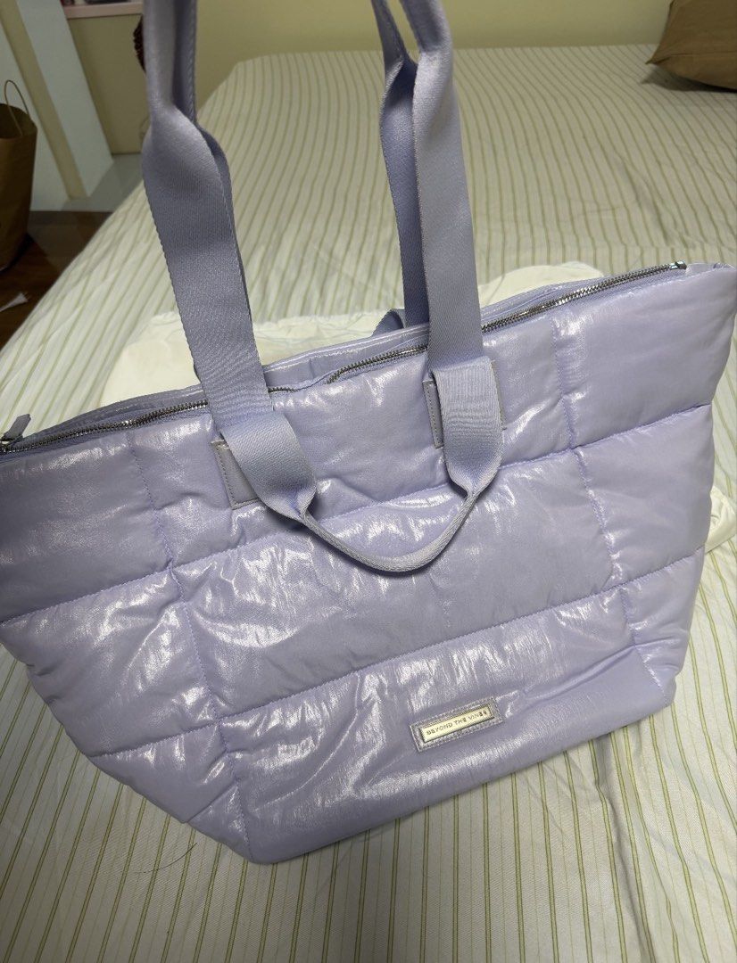 Beyond The Vines Puffer Tote Bag - Lilac (Category: Tote Bags) located in Manila. Submitted by amandada.doo (Listing ID 1463667737, Image 1). Description: - Lilac puffer tote bag from Beyond The Vines -Never been used - Shiny, quilted material - Zipper closure - Bright blue interior lining - Small interior pocket - Comes with a dust bag - Ideal for everyday use or travel.