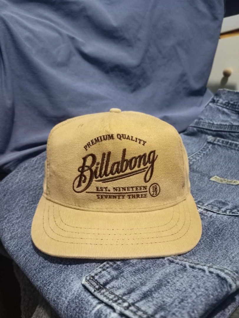 Billabong "Premium Quality" Snapback Cap (Category: Caps & Hats) located in Manila. Submitted by thecomftrift.co (Listing ID 1463718304, Image 2). Description: - Tan corduroy Billabong snapback cap - Features 'Premium Quality' and 'Billabong Est. 1973' embroidery on the front - 'Billabong Authentic Headwear' on the inside band - Adjustable strap at the back for a custom fit - Ideal for everyday casual wear.