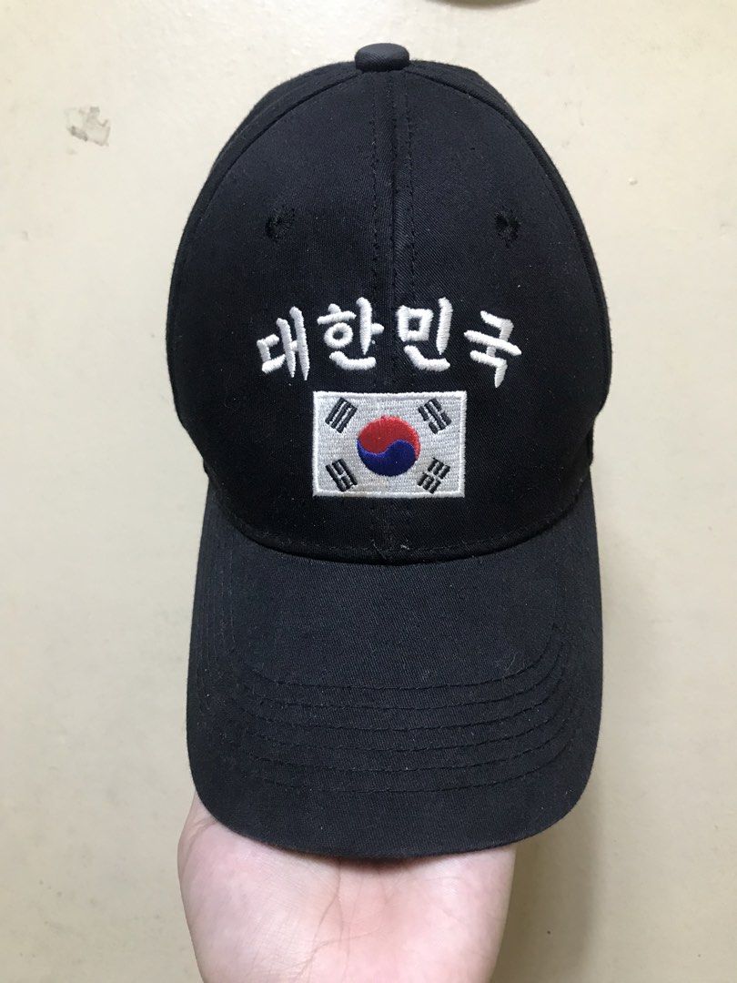 Black Baseball Cap with South Korea Flag and Text (Category: Caps & Hats) located in Baguio. Submitted by kurtshelby (Listing ID 1463611855, Image 2). Description: - Classic black baseball cap - Features embroidered Korean text '대한민국' (Daehan Minguk) and South Korean flag on the front - Adjustable strap with a metal buckle for a secure fit - 'BLUE' label inside, indicating one size fits most - Ideal for expressing national pride or as a stylish e