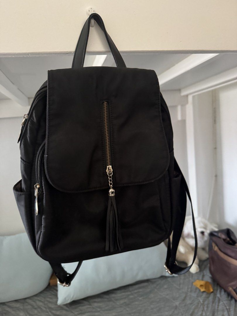 Black Nylon Backpack with Tassel Detail (Category: Backpacks) located in Las Pinas. Submitted by megalleon8 (Listing ID 1463573091, Image 1). Description: - Stylish black nylon backpack - Front zip pocket with a cute tassel charm - Wide-opening main compartment for easy access - Interior pockets for organized storage - Comfortable adjustable shoulder straps - Ideal for everyday errands or your next adventure.