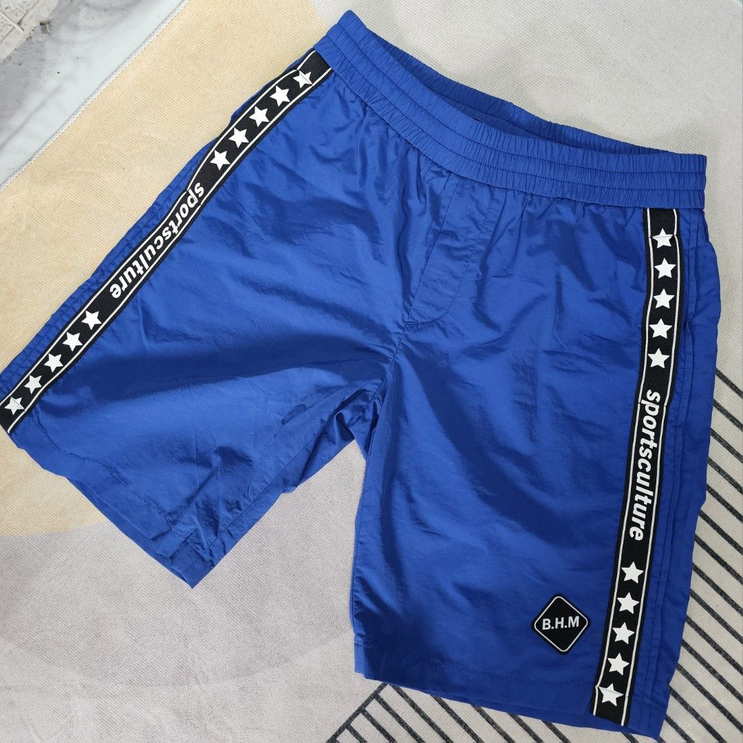 Blue Sport Shorts (Category: Shorts) located in Baguio. Submitted by kayeonlineshop (Listing ID 1463622533, Image 1). Description: blue athletic shorts with a side logo stripe that reads "sportsculture" alongside star patterns w32-38 l21 h24.