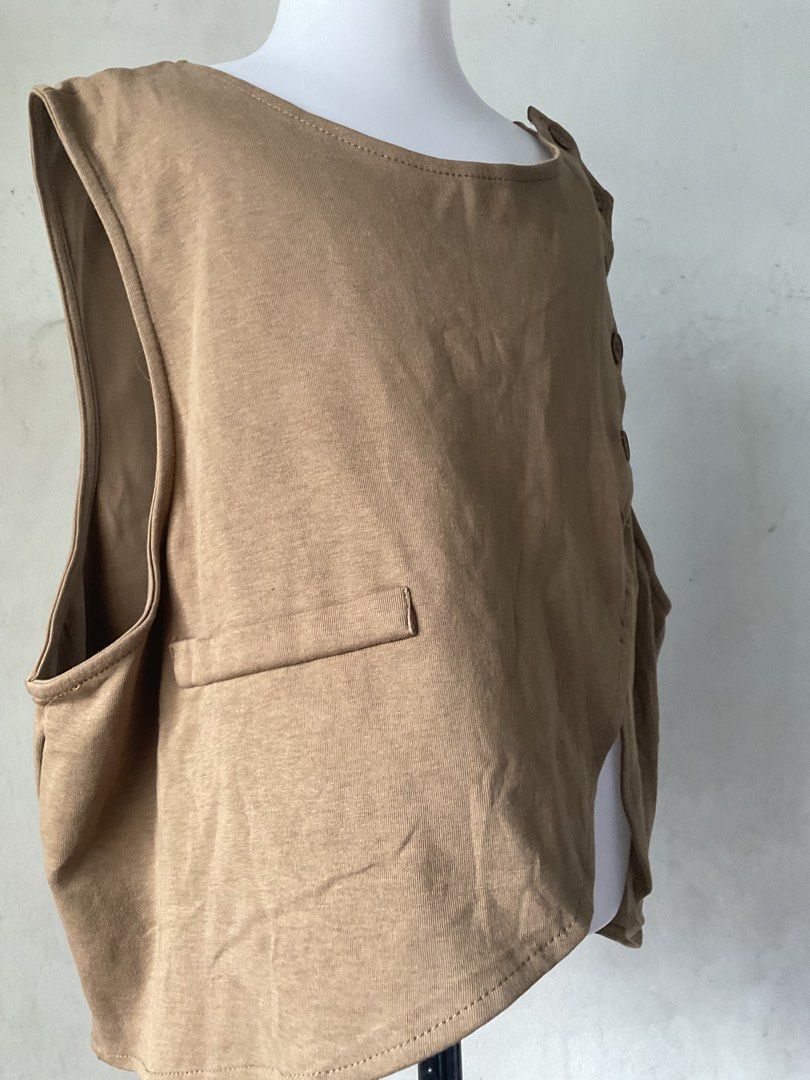 Brown Asymmetrical Button Vest with Pocket Detail (Category: Sleeveless) located in Manila. Submitted by horangborahae (Listing ID 1463604231, Image 3). Description: - Cool brown vest - Asymmetrical hemline - Unique side button closure - Small pocket detail - Open back with strap and ring detail - Ideal for layering over tops or dresses.