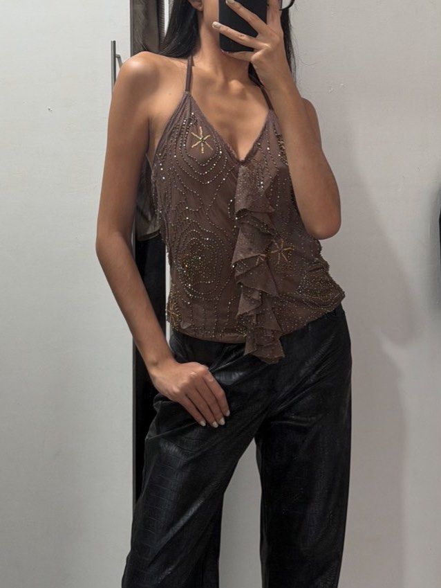 Brown Beaded Halter Top with Ruffles (Category: Sleeveless) located in Pasig City. Submitted by miss_abuelita (Listing ID 1462777587, Image 1). Description: - Cute brown halter top - Beaded details all over - Ruffled front - Straps tie at the neck - Versatile: pairs well with jeans or trousers - Ideal for night outs or special occasions - Unique piece.