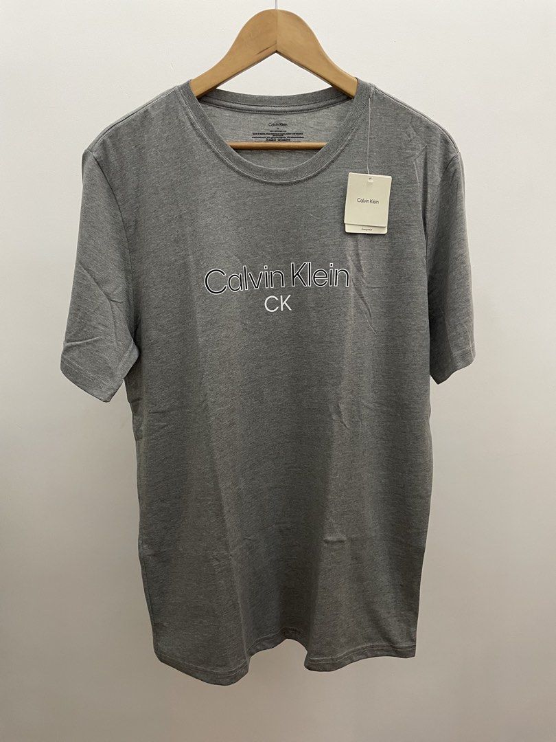 Calvin Klein Grey T-Shirt (Category: Tshirts & Polo Shirts ) located in San Fernando. Submitted by migifinds (Listing ID 1463659488, Image 1). Description: - Brand: Calvin Klein - Color: Grey - Size: Medium (M) - Material: Cotton Microfiber Blend - Condition: Brand New with Original Tag Attached - Features: Crew neck, short sleeves, subtle front logo, plain back - Brand new with tag attached Pm me for more details 📩 .