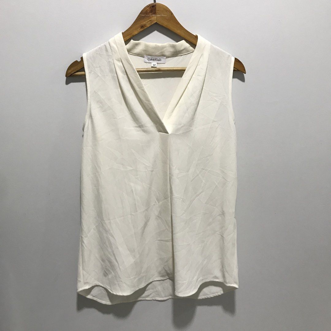 CALVIN KLEIN White Sleeveless Blouse (Category: Sleeveless) located in Cavite. Submitted by tanya.valentin (Listing ID 1463717083, Image 1). Description: - 20x29.