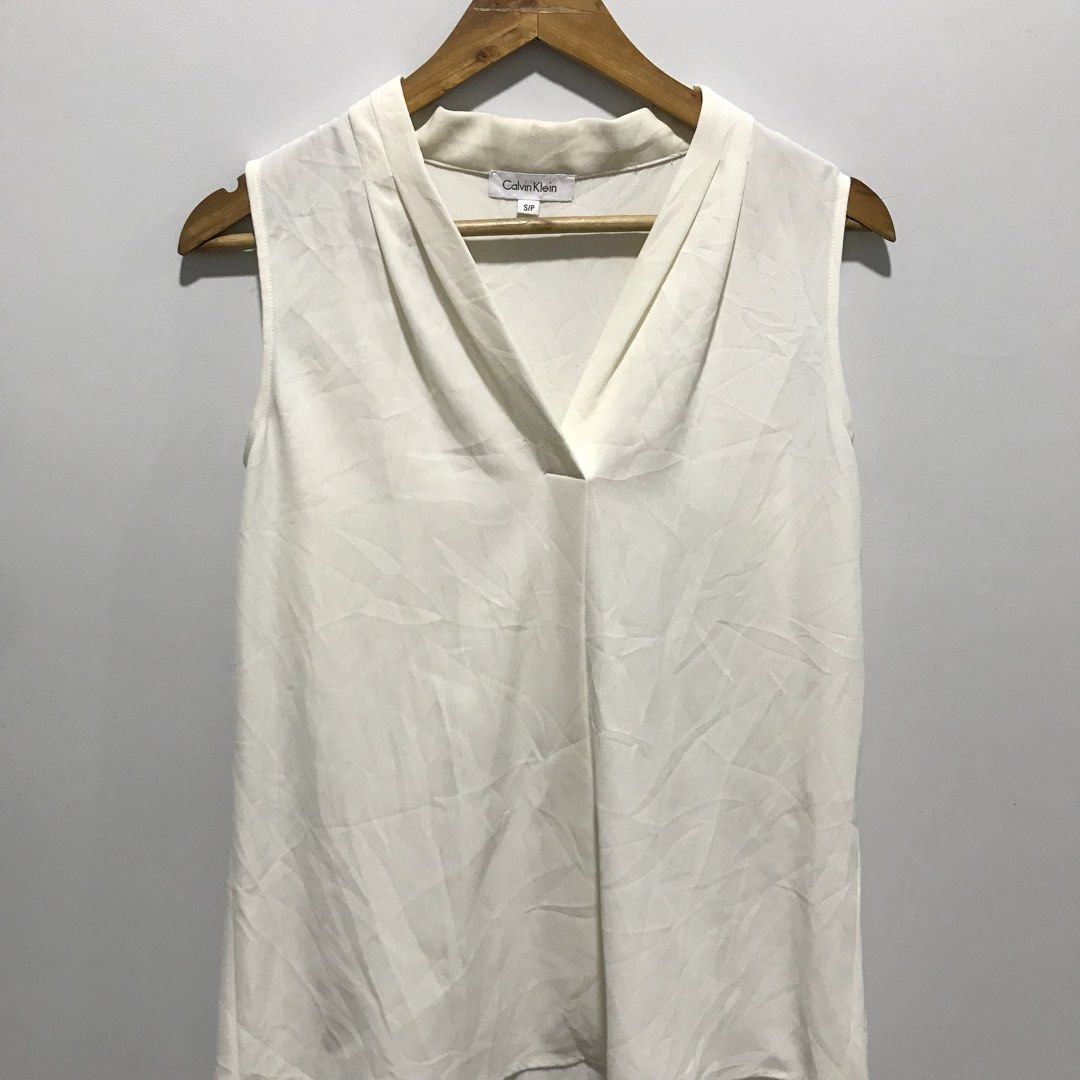 CALVIN KLEIN White Sleeveless Blouse (Category: Sleeveless) located in Cavite. Submitted by tanya.valentin (Listing ID 1463717083, Image 2). Description: - 20x29.