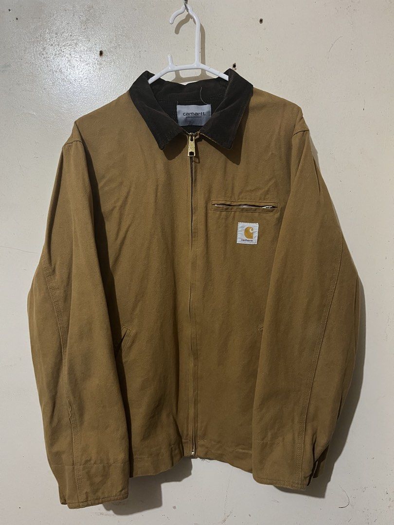Carhartt WIP Detroit Jacket (Category: Coats, Jackets and Outerwear) located in Baguio. Submitted by visentovi (Listing ID 1463631765, Image 1). Description: - Classic tan Carhartt jacket - Features a corduroy collar - Zip-up front with button closure - Chest pocket with zip and iconic Carhartt logo patch - Durable and stylish for everyday wear.