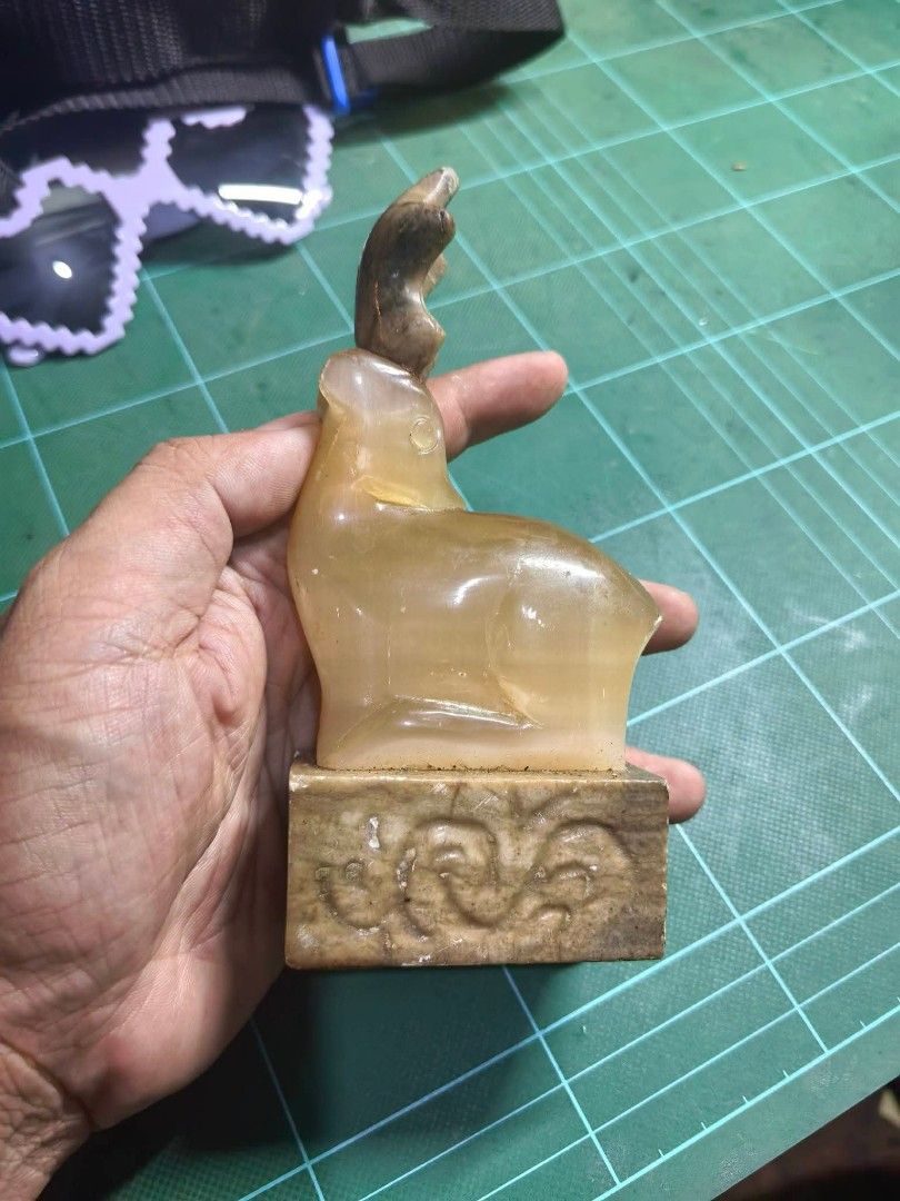 Carved Stone Seal Figurine (Category: Other Home Decor) located in Cebu City. Submitted by dudes_villanueva (Listing ID 1463656726, Image 1). Description: Carved Stone Seal Figurine 📌 Featuring a resting deer (or elk) atop a square base, resembling items carved from natural stone. 📌 Has visible scratches. Sold as is. 📌 Pricey sya pero benta Lang mura. L2.5xW2.5xH5.6 in.