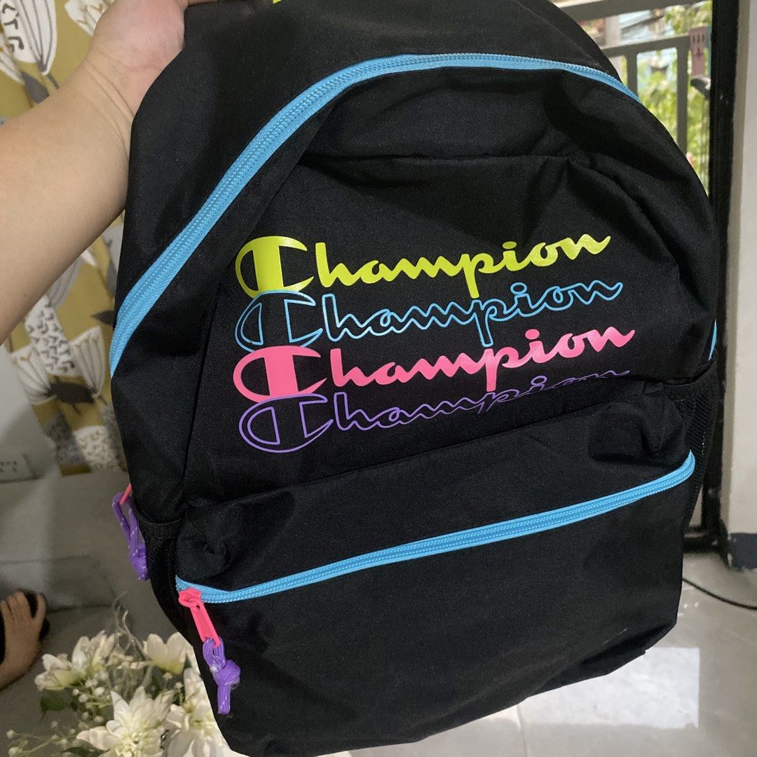 Champion Backpack Black Multi-Color Logo (Category: Backpacks) located in Taguig. Submitted by mixmix16 (Listing ID 1463658066, Image 1). Description: - Authentic Champion backpack - Eye-catching multi-color stacked logo on front - Vibrant blue zipper trim with pink pulls and purple cord details - Comfortable neon yellow padded shoulder straps - Vertical embroidered Champion logo on the back - Bright pink interior lining - Ample space for all you