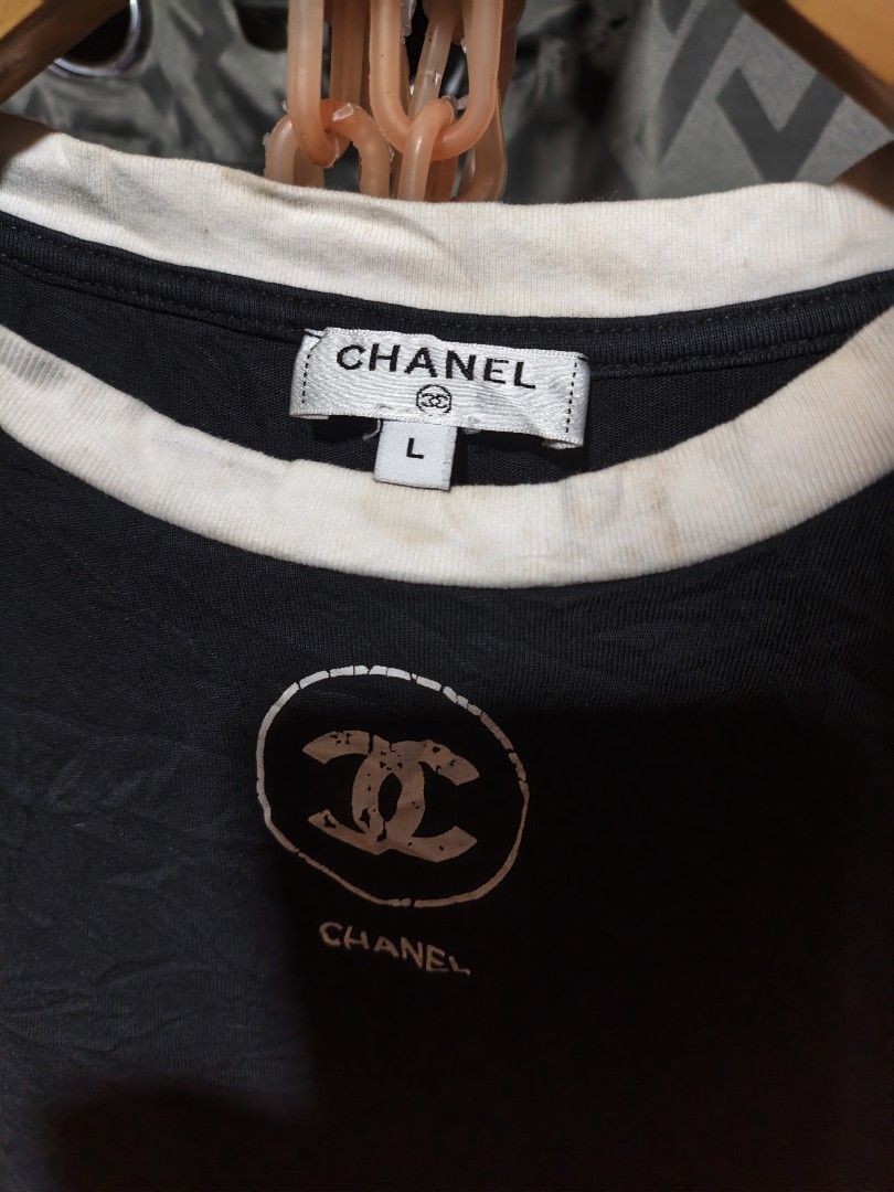 Chanel Black T-Shirt Size L (Category: Shirts) located in Maasim. Submitted by ukayganda25 (Listing ID 1463656799, Image 2). Description: - Authentic Chanel T-shirt - Color: Black with white neckline trim - Features iconic Chanel CC logo - Size: L - Material: 100% Cotton - Made in Italy - Ideal for casual wear -need wash -19*20.5 dimensions .