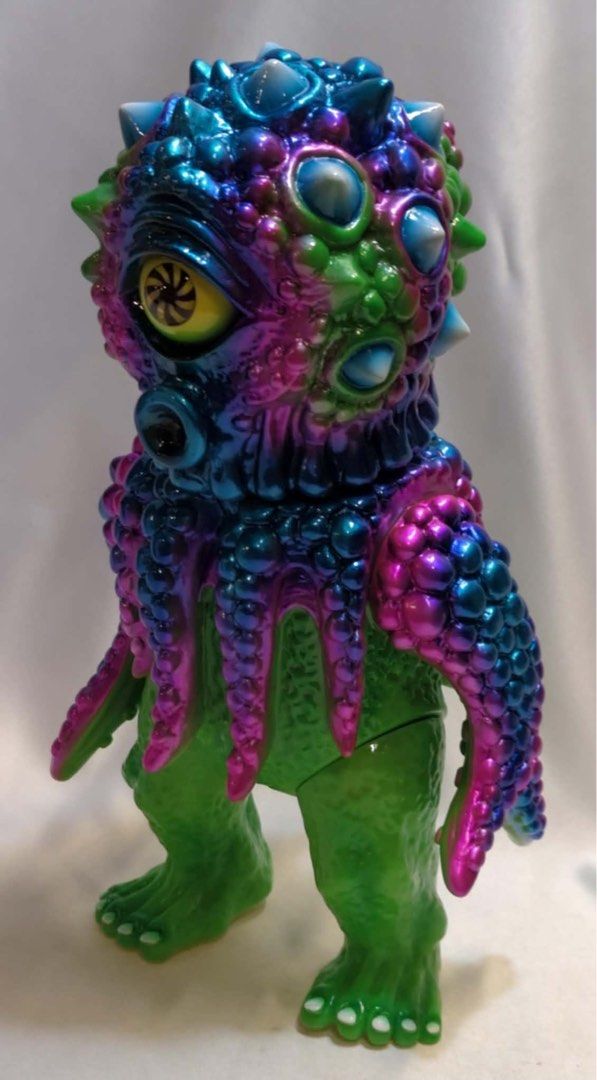 ChokeHazrd Parasquid Sofubi 25cm (Category: Figurines & Statues) located in Quezon City. Submitted by jmp923 (Listing ID 1463590553, Image 3). Description: - Designer toy from Choke Hazrd - 2nd release 2022 - Made in Japan - Unique iridescent paint (green, blue, pink) - One-eyed monster with tentacle arms - Excellent collectible for toy enthusiasts - Stands on its own - Detailed feet.