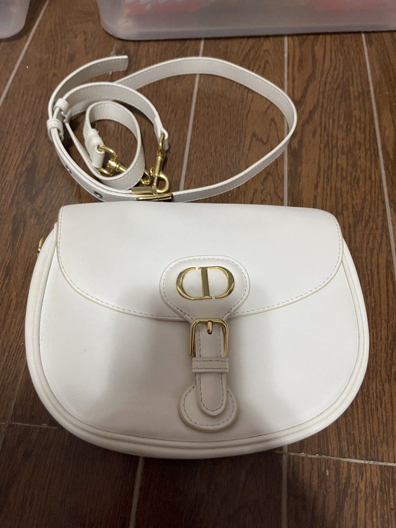 Christian Dior CD Logo White Leather Shoulder Bag (Category: Luxury Bags & Wallets) located in Victorias. Submitted by lan1877 (Listing ID 1463608087, Image 1). Description: - Iconic gold hardware CD logo clasp - Adjustable shoulder strap - Made in Italy - Exterior in clean condition Issue nsa last pics Rank a - Interior shows some signs of use.